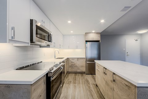 a modern kitchen with white counter tops and stainless steel appliances